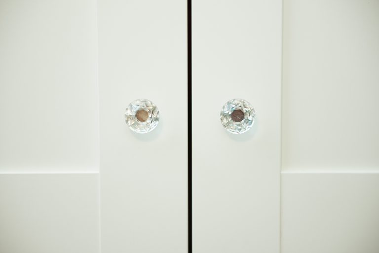 white kitchen cabinet door with trendy glass knobs