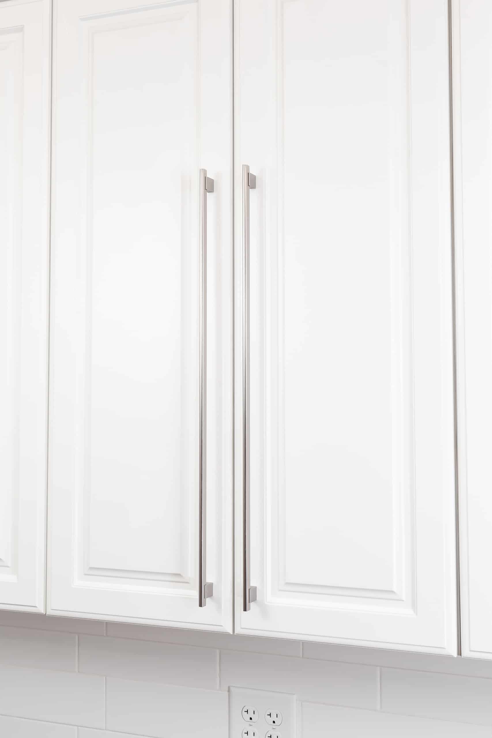 White kitchen cabinet door panel installed long handle pulls